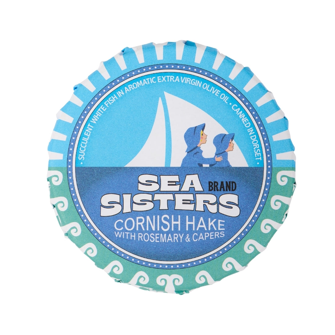 A single round Sea Sisters Cornish Hake wrap with a blue and white label, featuring a sailboat illustration and the text 'SEA SISTERS BRAND' on a plain white background.